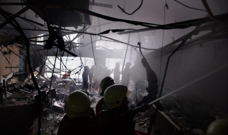 Petugas pemadam kebakaran berusaha memadamkan api yang membakar sebuah restoran cepat saji di Stasiun Gambir, Jakarta Pusat, Jumat (27/12). 