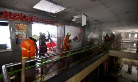 Petugas pemadam kebakaran berusaha memadamkan api yang membakar sebuah restoran cepat saji di Stasiun Gambir, Jakarta Pusat, Jumat (27/12). 