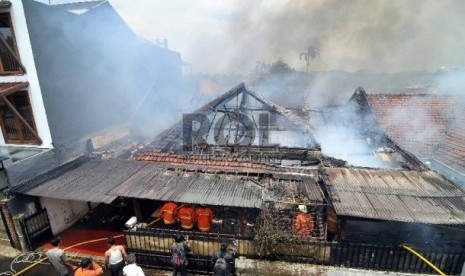 Petugas pemadam kebakaran berusaha memadamkan api yang menghanguskan sebuah rumah di Jalan Palem, Pasar Minggu, Jakarta Selatan, Senin (23/2).  