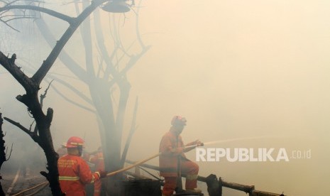 Petugas pemadam kebakaran berusaha memadamkan sisa api saat terjadi kebakaran di kawasan permukiman penduduk, di Cipinang Muara, Jakarta, Senin (21/5).