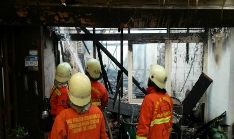  Petugas pemadam kebakaran berusaha mengendalikan api yang melalap sebuah rumah di jalan Palem, RT 01 RW 07, Pejaten,Pasarminggu. 