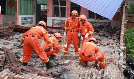 Petugas pemadam kebakaran cina mencoba mengevakuasi korban dari balik dinding bangunan yang runtuh. Gempa kembar mengguncang negara itu pada Jumat (7/9/2012)