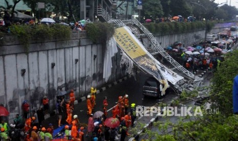 Petugas pemadam kebakaran dan Dishub berusaha mengevakuasi jembatan penyebrangan orang (JPO) yang ambruk di Pasar Minggu, Jakarta, Sabtu (24/9).