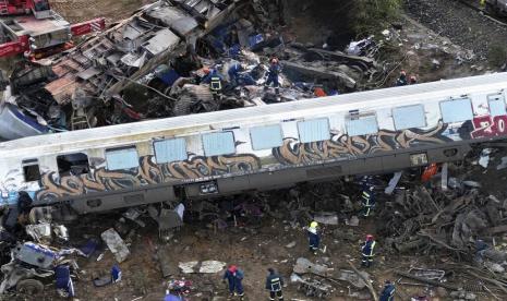 Petugas pemadam kebakaran dan penyelamat beroperasi setelah tabrakan di Tempe dekat kota Larissa, Yunani, Rabu, 1 Maret 2023. Sebuah kereta yang membawa ratusan penumpang bertabrakan dengan kereta barang yang melaju di Yunani utara, menewaskan dan melukai puluhan penumpang. 