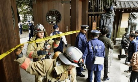 Petugas pemadam kebakaran dan polisi memeriksa kuil tempat terjadi ledakan di kuil Yasukuni, Tokyo, Senin (23/11).