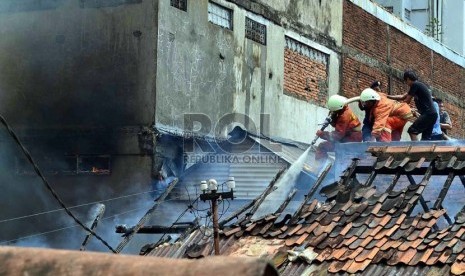  Petugas Pemadam kebakaran dibantu warga berusaha memadamkan rumah yang terbakar di Jalan Salemba, Senen, Jakarta Pusat, Selasa (12/3).   (Republika/ Agung Supriyanto)