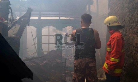  Petugas Pemadam kebakaran dibantu warga berusaha memadamkan rumah yang terbakar di Jalan Salemba, Senen, Jakarta Pusat, Selasa (12/3).   (Republika/ Agung Supriyanto)