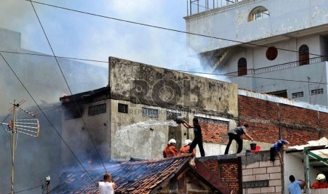  Petugas Pemadam kebakaran dibantu warga berusaha memadamkan rumah yang terbakar di Jalan Salemba, Senen, Jakarta Pusat, Selasa (12/3).   (Republika/ Agung Supriyanto)