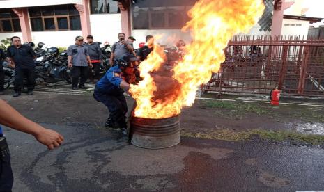 Petugas pemadam kebakaran Kabupaten Kuningan sedang memberikan pelatihan pemadaman kebakaran. 