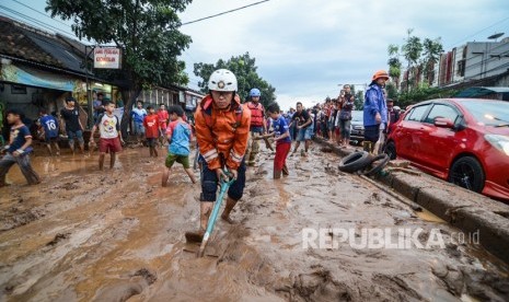 Petugas pemadam kebakaran Kota Bandung membersihkan lumpur akibat banjir bandang di Jalan A.H Nasution, Bandung, Jawa Barat, Selasa (20/3).