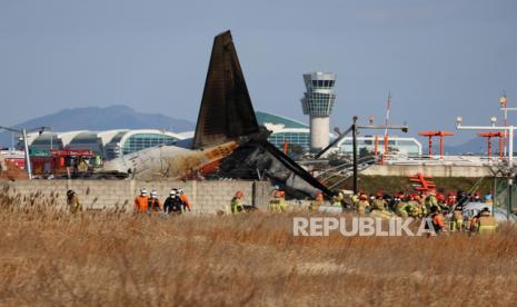 Petugas pemadam kebakaran melakukan operasi penyelamatan di Bandara Internasional Muan di Muan, 288 kilometer barat daya Seoul, Korea Selatan, Ahad, 29 Desember 2024, setelah sebuah pesawat penumpang Jeju Air yang berangkat dari Bangkok, Thailand, jatuh saat mendarat..