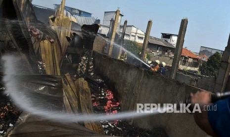 Petugas pemadam kebakaran melakukan pendinginan saat terjadi kebakaran di Jalan Jati Bundar, Tanah Abang, Jakarta, Ahad (30/6/2019).