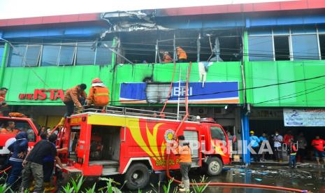 Petugas pemadam kebakaran melalukan pendinginan dilokasi kebakaran di salah satu bank di Kudus, Jawa Tengah, Kamis (13/1/2022). Kebakaran yang disebabkan hubungan arus pendek itu mengakibatkan kerugian hingga puluhan juta rupiah serta membakar sejumlah arsip bank tersebut. 