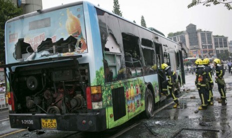 Petugas pemadam kebakaran memadam api yang membakar sebuah bus di jalanan Kota Hangzhou, Zhejiang, Cina, Sabtu (5/7).  