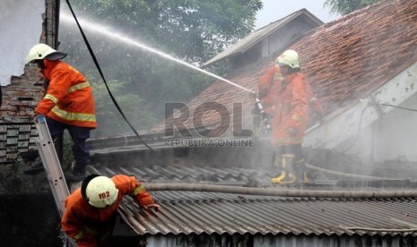 Petugas pemadam kebakaran memadamkan api saat kebakaran yang melanda sebuah rumah. (ilustrasi). Polisi menyelidiki kebakaran rumah di Gunung Putri yang menyebabkan pemiliknya tewas.