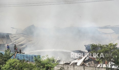 Petugas pemadam kebakaran memadamkan api yang membakar gudang di Deyuhkolot, Kabupaten Bandung, Jawa Barat, Kamis (31/5). 