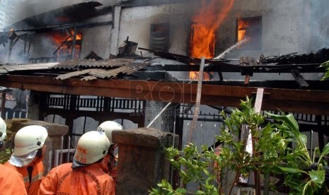  Petugas pemadam kebakaran memadamkan api yang membakar satu rumah warga di Petamburan RT 06 RW 06, Tanah Abang, Jakarta Pusat, Kamis (11/10). (Agung Fatma Putra)