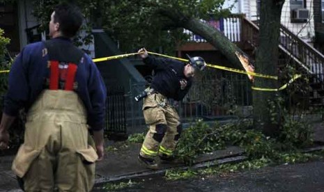  Petugas pemadam kebakaran memeriksa pohon tumbang akibat badai Sandy di Jersey City, New Jersey, Senin (29/10) waktu setempat. 