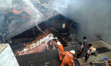  Petugas pemadam kebakaran mencoba memadamkan api saat kebaran di pemukiman padat di Kelurahan Kramat, Senen, Jakarta Pusat, Jumat (24/8). (Wihdan Hidayat/Republika)