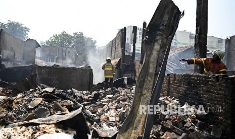 Petugas pemadam kebakaran mengamati api yang membakar kios di Jalan Jati Bundar, Tanah Abang, Jakarta, Ahad (30/6/2019).