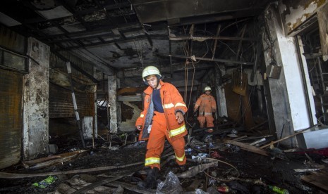 Petugas pemadam kebakaran mengecek sisa kios yang terbakar di Pasar Senen, Jakarta Pusat, Jumat (20/1). 