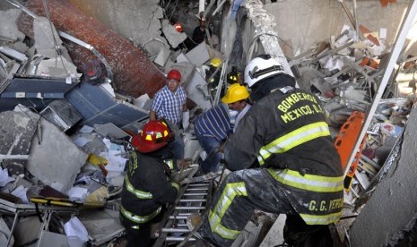 Petugas pemadam kebakaran menggali reruntuhan ledakan di sebuah bangunan yang berdekatan dengan gedung Pemex, perusahaan minyak milik negara di Mexico City, Kamis (31/1).  (AP/Guillermo Gutierrez)