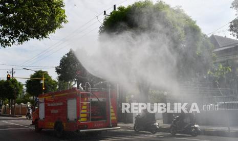 Petugas pemadam kebakaran menyemprotkan cairan disinfektan di fasilitas umum Kota Madiun, Jawa Timur, Rabu (2/2/2022). Pemkot Madiun melakukan penyemprotan cairan disinfektan secara massal di sejumlah lokasi yang banyak dikunjungi warga dengan melibatkan petugas gabungan dari Pemadam Kebakaran, BPBD, PMI, Dinas Pekerjaan Umum dan Dinas Perdagangan guna mengendalikan penyebaran COVID-19 seiring meningkatnya kambali kasus positif COVID-19. 