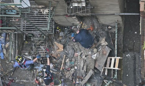 Petugas pemadam kebakaran menyingkirkan runtuhan bangunan setelah kebakaran melanda kawasan Chinatown di Manhattan, New York, Amerika Serikat, Kamis (11/7). 