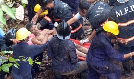 Petugas pemadam kebakaran tengah membantu korban geduh yang ambruk di Mumbai, India