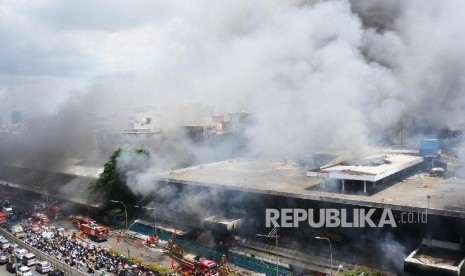 Petugas pemadam kebakaran terus berusaha menjinakkan si jago merah yang membakar pusat perbelanjaan proyek Senen Jakarta, Kamis (19/1).