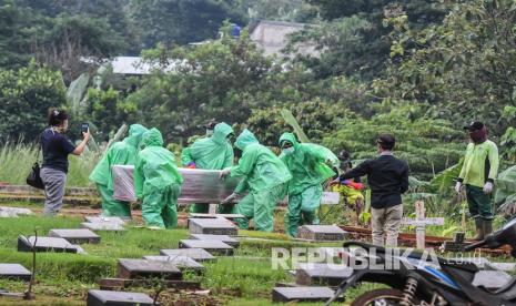 Petugas pemakaman membawa peti jenazah pasien COVID-19 di TPU Pondok Ranggon, Jakarta, Senin (30/3/2020). Juru bicara pemerintah untuk penanganan COVID-19 Achmad Yurianto per Senin (30/3) pukul 12.00 WIB menyatakan jumlah pasien positif COVID-19 di Indonesia telah mencapai 1.414 kasus, pasien yang telah dinyatakan sembuh sebanyak 75 orang, sementara kasus kematian bertambah delapan orang dari sebelumnya 114 orang menjadi 122 orang.