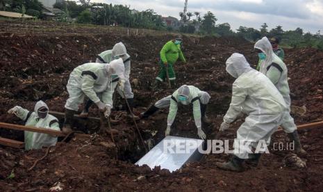 Petugas pemakaman menguburkan jenazah korban COVID-19 di TPU Srengseng Sawah Dua, Jagakarsa, Jakarta Selatan, Selasa, (2/2/2021). Kepala Pusat Data dan Informasi (Kapusdatin) Dinas Pertamanan dan Pemakaman DKI Jakarta Ivan Murcahyo menyatakan TPU Srengseng Sawah dua telah mulai menerima pemakaman jenazah COVID-19 dengan kapasitas 1.020 petak. 