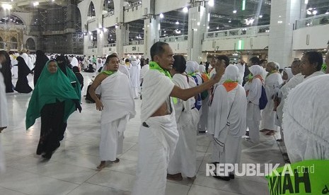 Petugas pembimbing mengatur jamaah calon haji Indonesia yang baru tiba dari Madinah di pelataran Masjid al-Haram sebelum melakukan umrah sebagai bagian dari pelaksanaan haji tamattu