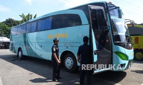 Petugas pemeriksaan kendaraan angkutan darat antar kota antar provinsi (AKAP) di Terminal Kampung Rambutan, Jumat (24/6). (Republika/ Yasin Habibi)