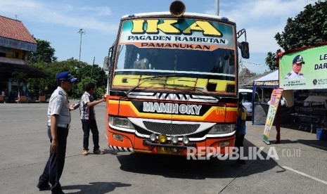 Petugas pemeriksaan kendaraan angkutan darat antar kota antar provinsi (AKAP) di Terminal Kampung Rambutan, Jumat (24/6). (Republika/ Yasin Habibi)