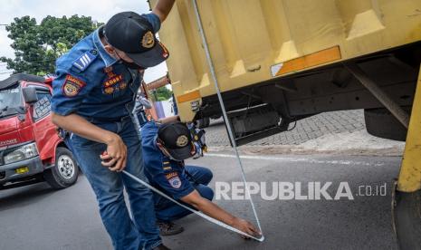 Petugas Penguji Kendaraan Bermotor Dinas Perhubungan Kota Semarang mengukur dimensi kendaran bermotor dalam kegiatan operasi Pengawasan dan Penindakan Kendaraan Bermotor Overdimension dan Overload (ODOL) atau kelebihan dimensi dan muatan di Tembalang, Semarang, Jawa Tengah, Senin (13/9/2021). Operasi gabungan Dishub Kota Semarang bersama Satlantas Polrestabes Semarang tersebut guna menertibkan kendaraan berat muatan barang agar sesuai dengan aturan lalu lintas yang berlaku sebagai upaya menjaga keamanan, kenyamanan, serta keselamatan pengendara di jalan raya.