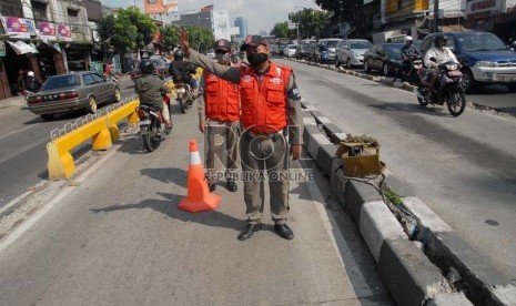   Petugas penjaga jalur busway menghalau sejumlah pengendara kendaraan bermotor yang hendak melintasi jalur busway di jalan Warung Buncit, Jakarta Selatan, Rabu (28/11).  (Republika/Agung Fatma Putra)