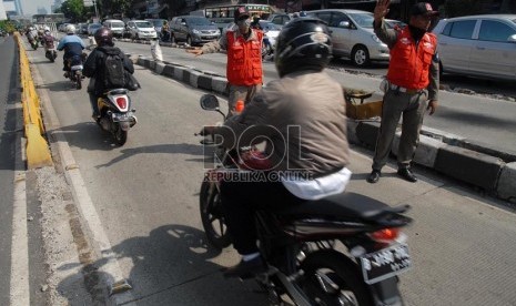   Petugas penjaga jalur busway menghalau sejumlah pengendara kendaraan bermotor yang hendak melintasi jalur busway di jalan Warung Buncit, Jakarta Selatan, Rabu (28/11).  (Republika/Agung Fatma Putra)