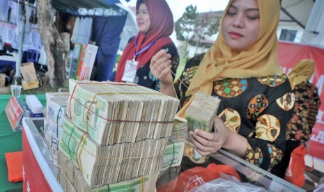 Petugas penukaran uang menyusun pecahan kertas uang Riyal di salah satu stan penukaran uang di Asrama Haji Palembang, Sumsel, Jumat (20/7). 