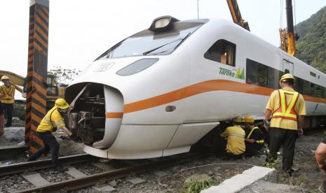  Petugas penyelamat memindahkan sebagian dari kereta yang tergelincir di dekat Ngarai Taroko di Hualien, Taiwan pada hari Sabtu, 3 April 2021.