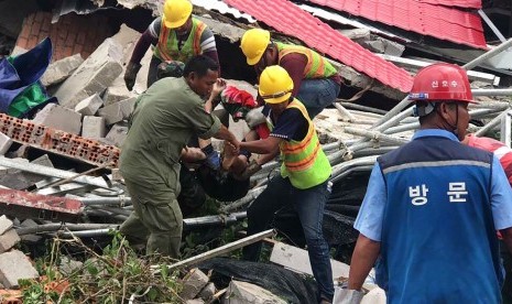 Petugas penyelamat mengevakuasi korban ambruknya gedung di Provinsi Preah Sihanouk, Kamboja, Sabtu (22/6).