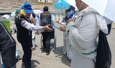 Petugas penyelenggara ibadah haji PPIH Arab Saudi bidang kesehatan terlihat sedang membagikan minuman kepada jamaah haji. Hari ini merupakan agenda jamaah haji melempar Jumroh Akobah, Sabtu (9/7). Rapat Evaluasi Puncak Haji Catat 12 Hal yang Harus Diperbaiki 