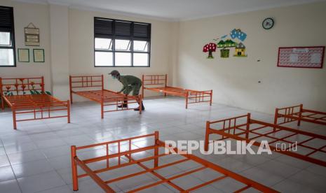 Petugas Perlindungan Masyarakat (Linmas) menyiapkan tempat tidur di dalam ruang kelas di SD Negeri Cengklik, Banjarsari, Solo, Jawa Tengah, Kamis (22/7/2021). Sebanyak 17 ruang kelas akan dimanfaatkan untuk isolasi terpusat Orang Tanpa Gejala (OTG) COVID-19 dengan kapasitas 120 tempat tidur untuk meminimalisir penularan dan perawatan orang terkonfirmasi positif COVID-19 lebih efektif. 