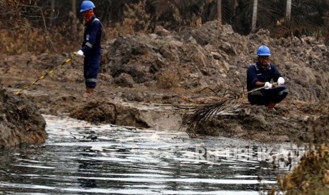 Petugas Pertamina mengawasi saluran pembuangan cairan minyak (Lesser) dari lubang ledakan sumur minyak illegal warga di Desa Pasir Putih, Ranto Panjang Peureulak, Kabupaten Aceh Timur, Kamis (26/4).