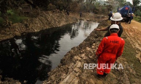 Petugas Pertamina mengawasi saluran pembuangan cairan minyak (Lesser) yang dialirkan dari lubang ledakan sumur minyak illegal warga di Desa Pasir Putih, Ranto Panjang Peureulak, Aceh Timur, Kamis (26/4).