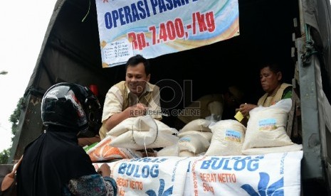 Petugas Perum Badan Urusan Logistik (Bulog) melayani warga yang membeli beras bulog saat digelarnya oprasi pasar beras dikawasan Pasar Jatinegara, Jakarta, Rabu (18/2).