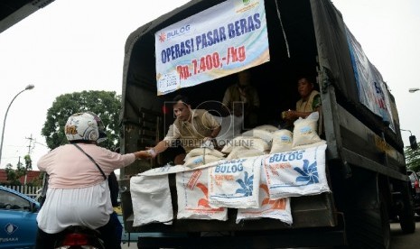 Petugas Perum Badan Urusan Logistik (Bulog) melayani warga yang membeli beras bulog saat digelarnya oprasi pasar beras dikawasan Pasar Jatinegara, Jakarta, Rabu (18/2).