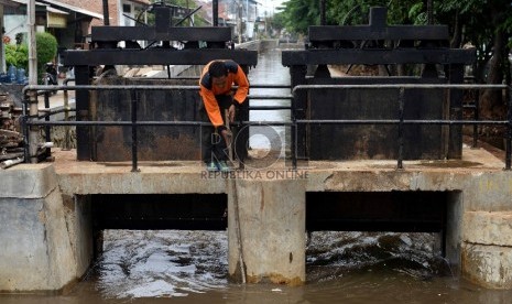  Petugas pintu air melakukan pembersihan kisi-kisi pintu air dari sampah di Pintu Air Hek Kramatjati, Jakarta Timur, Selasa (17/11).  (Republika/Wihdan)