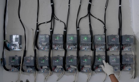 Petugas PLN Area Bulungan Distribusi Jakarta Raya melakukan penyambungan penambahan daya pelanggan 1300 VA menjadi 2200 VA di kawasan Kebayoran Lama, Jakarta Selatan, Selasa (20/6).