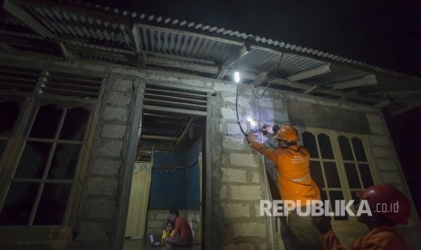 Petugas PLN memeriksa aliran listrik melalui alat meter listrik di salah satu rumah di Desa Lifuleo, Dusun Panaf, Kabupaten Kupang, Nusa Tenggara Timur, Kamis (20/7) malam. 